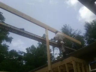 Carpenter setting a ridge beam over a new addition frame — Ice Dam Removal by Roofing Brothers in South Deerfield