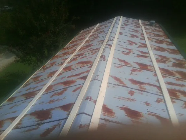 Rusted metal roof panels with new wood purlins before replacement — Storm Damage Roof Repair in South Deerfield by Roofing Brothers
