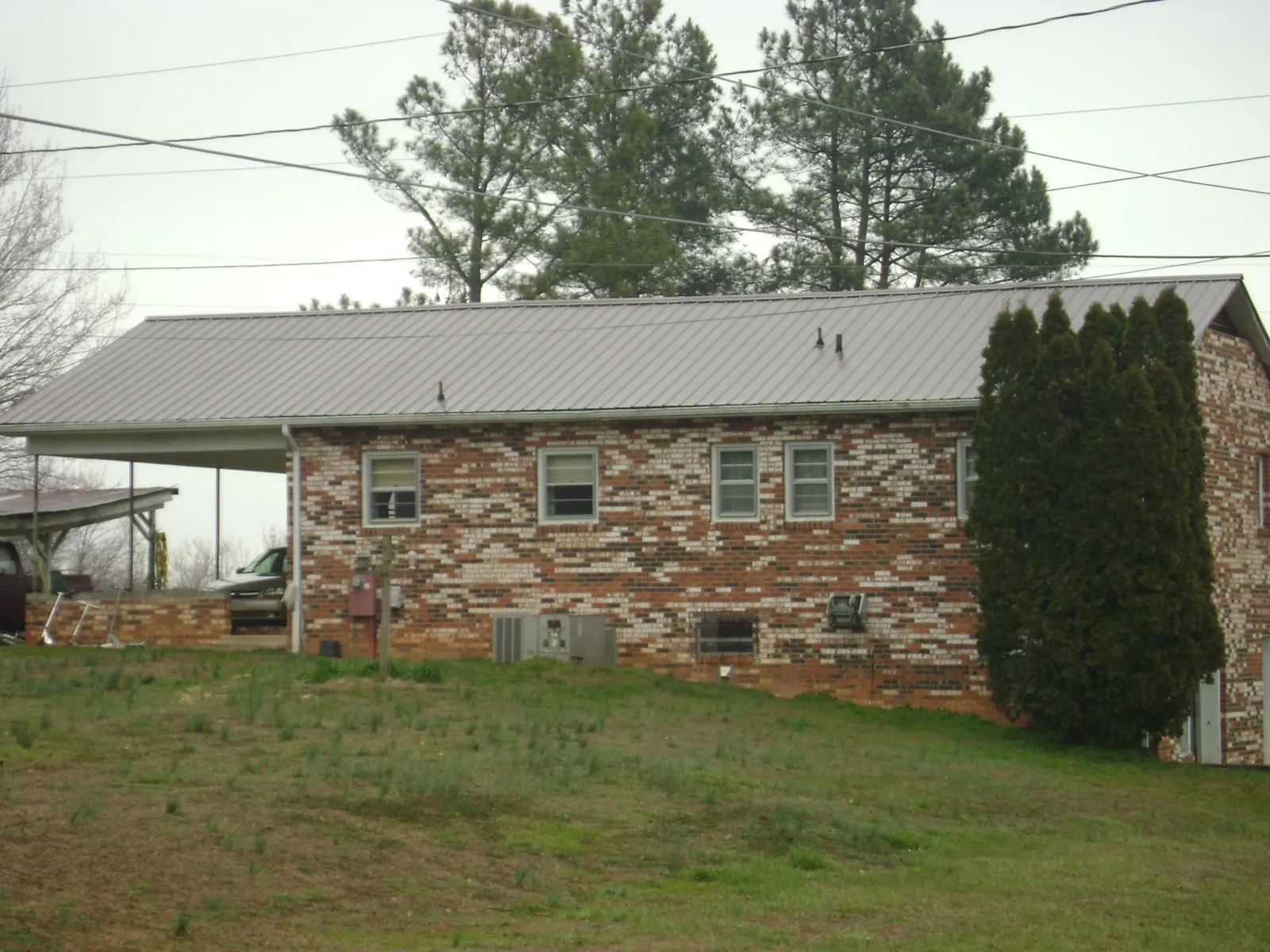 Gray metal roof on a brick split level home with a carport in South Deerfield