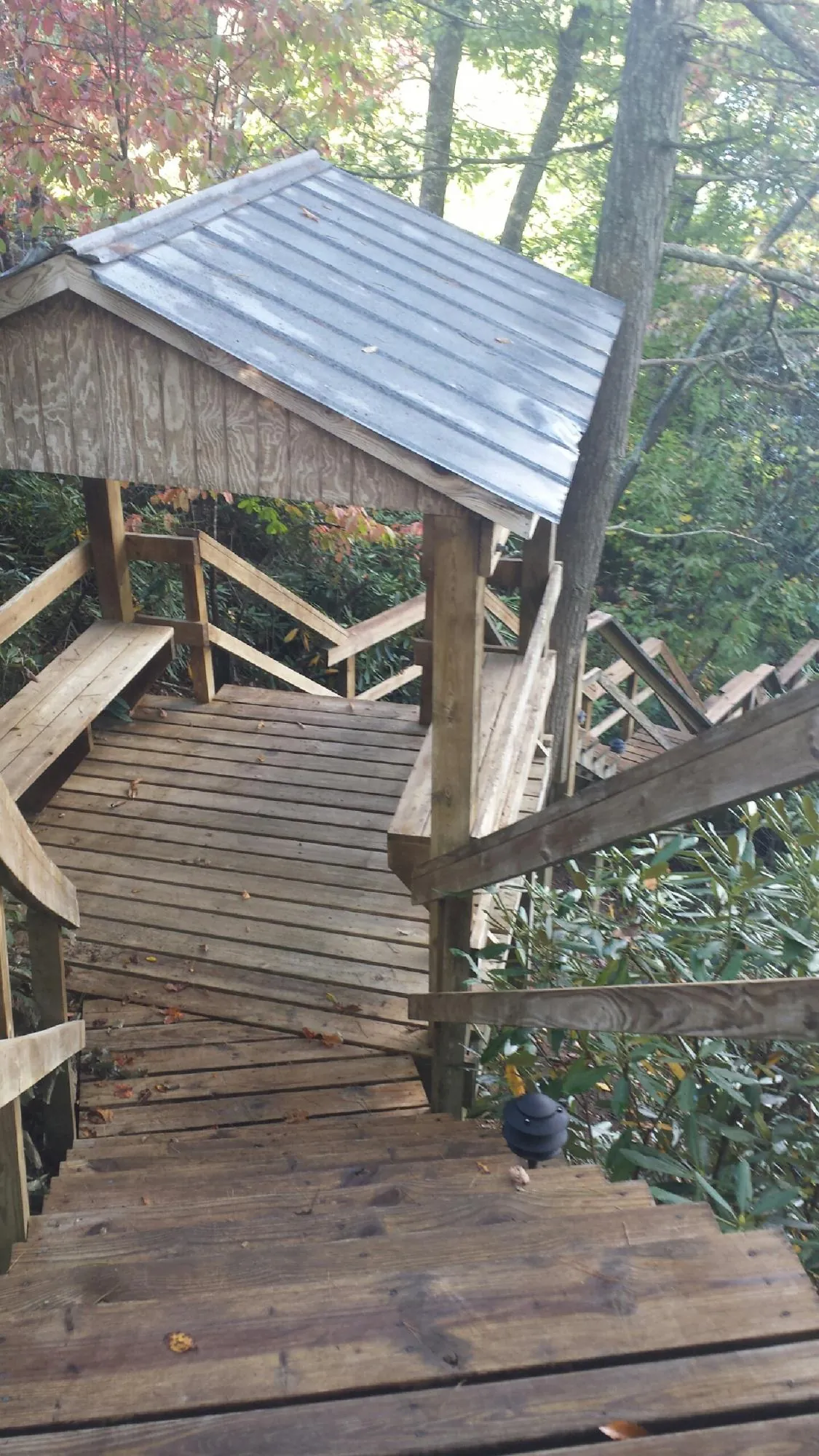 Metal roofed shelter over wooden steps on a wooded walkway — Skylight Repair & Installation work by our crew in South Deerfield
