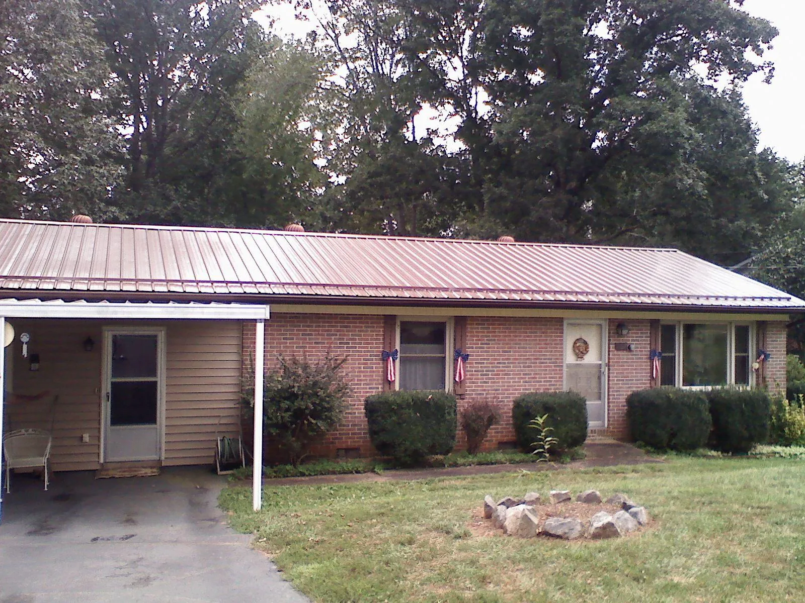 Bronze metal roof and carport on a brick ranch home — Roof Repair work by our crew in South Deerfield